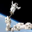 Astronaut Stephen K. Robinson, STS-114 mission specialist, anchored to a foot restraint on the extended International Space Station’s Canadarm2, participates in the mission's third session of extravehicular activity